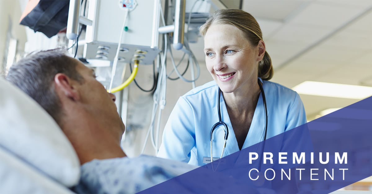 Smiling doctor looking at patient in hospital ward