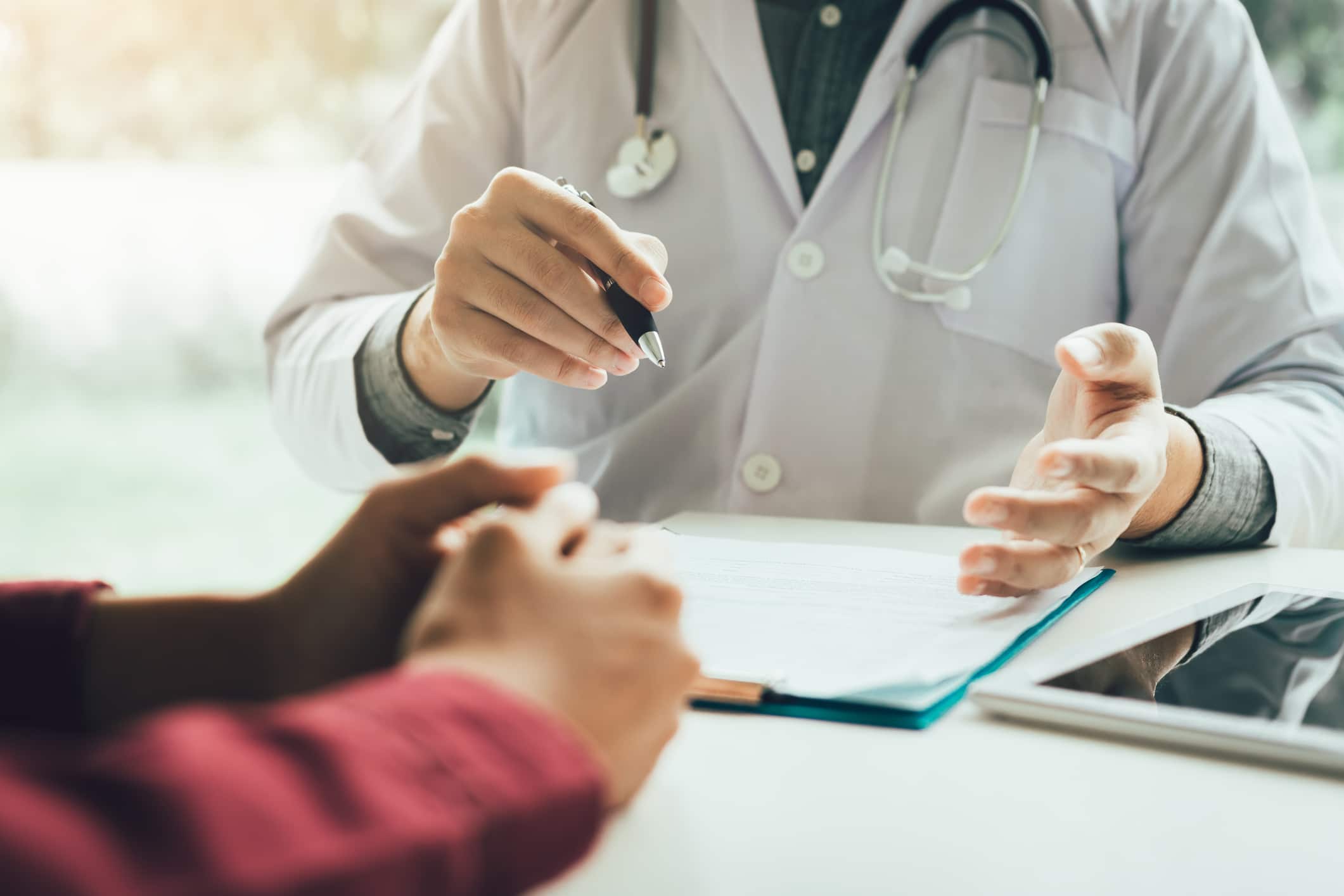 Doctor going through paperwork with a patient while sitting at a table